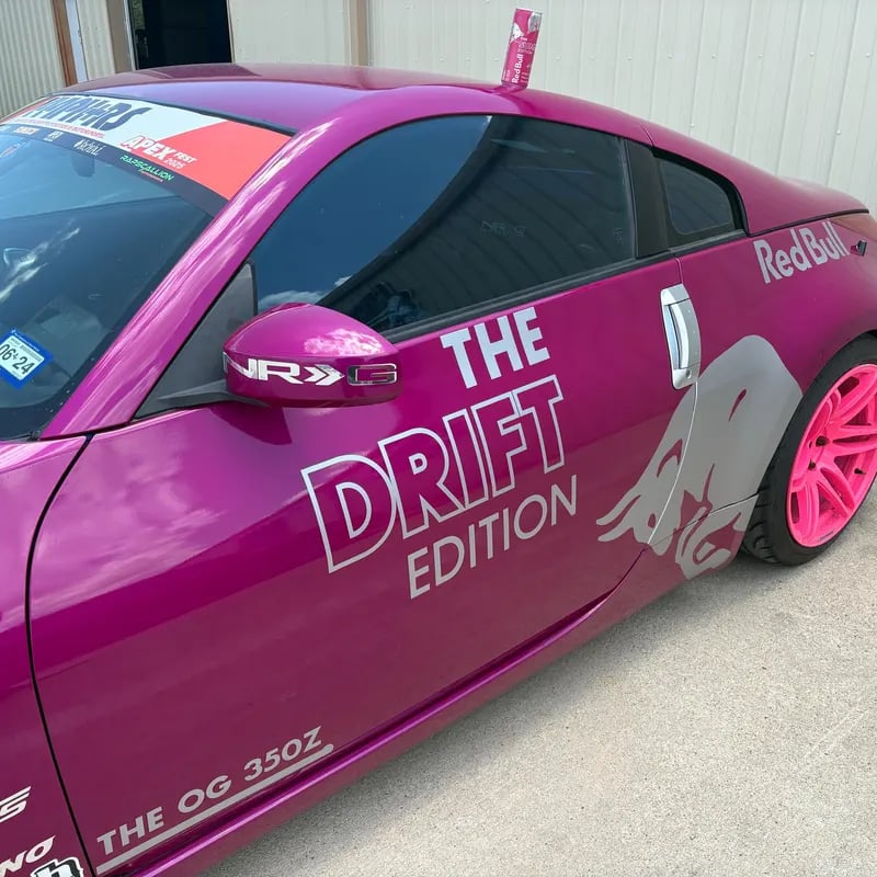 Pink car with 'Red Bull' and 'The Drift Edition' branding on a concrete surface.