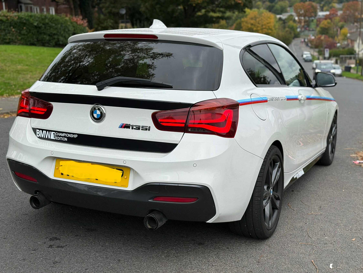 White BMW car with M35i badge and championship stripes